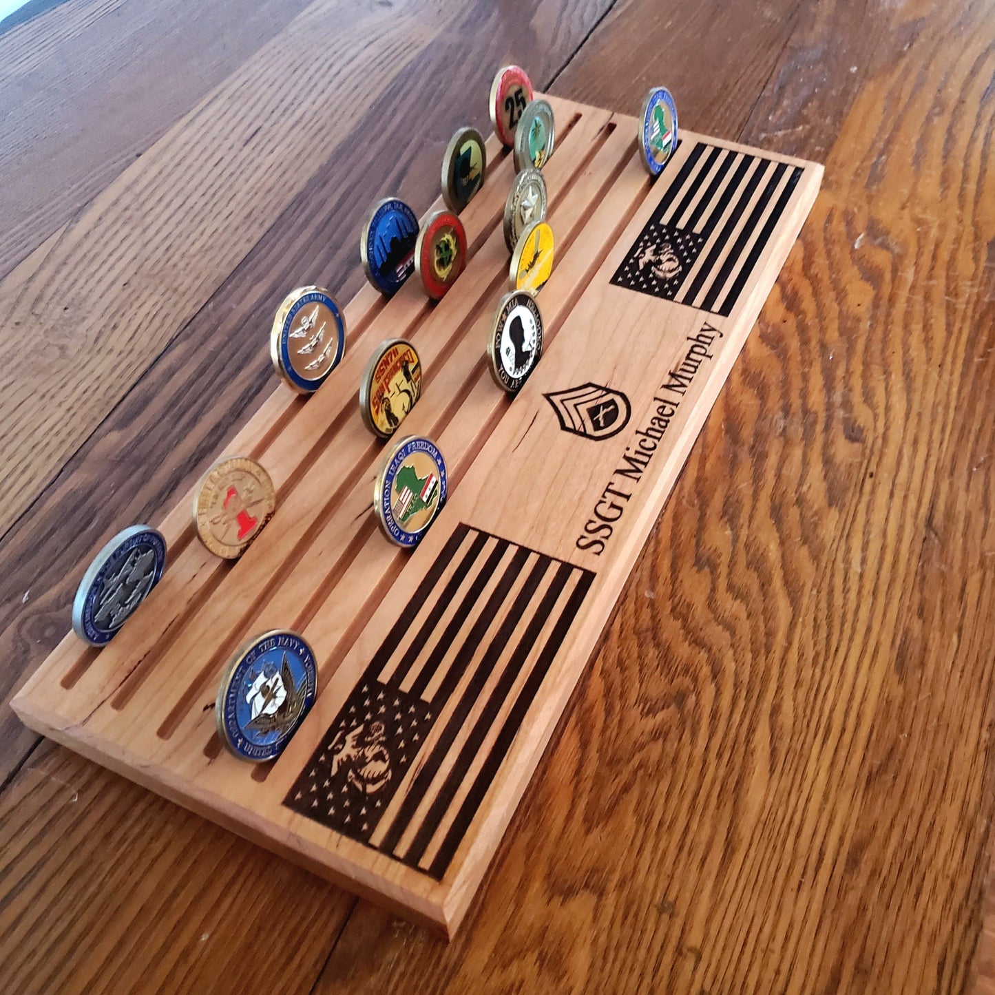 A handcrafted wooden USMC challenge coin display with five engraved slots, holding various military challenge coins.