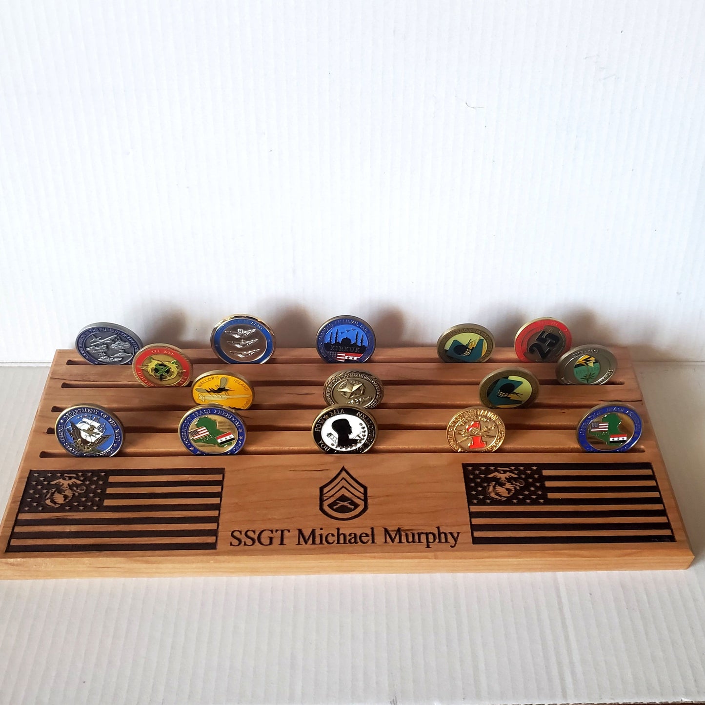The wood has a natural finish, highlighting the engraved details. The display rests on a wooden surface against a neutral background.