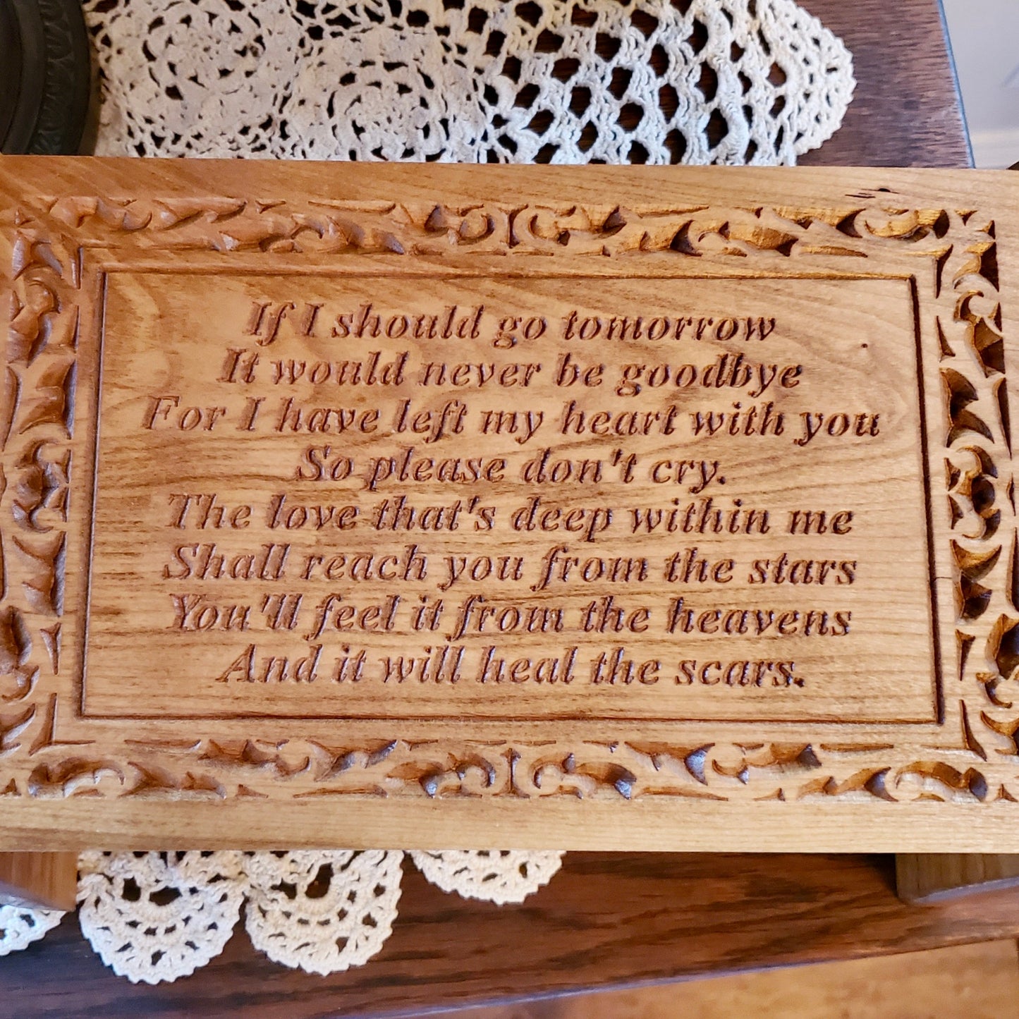 close-up of the personalized monogram engraved on the front panel of the cherry wood urn.